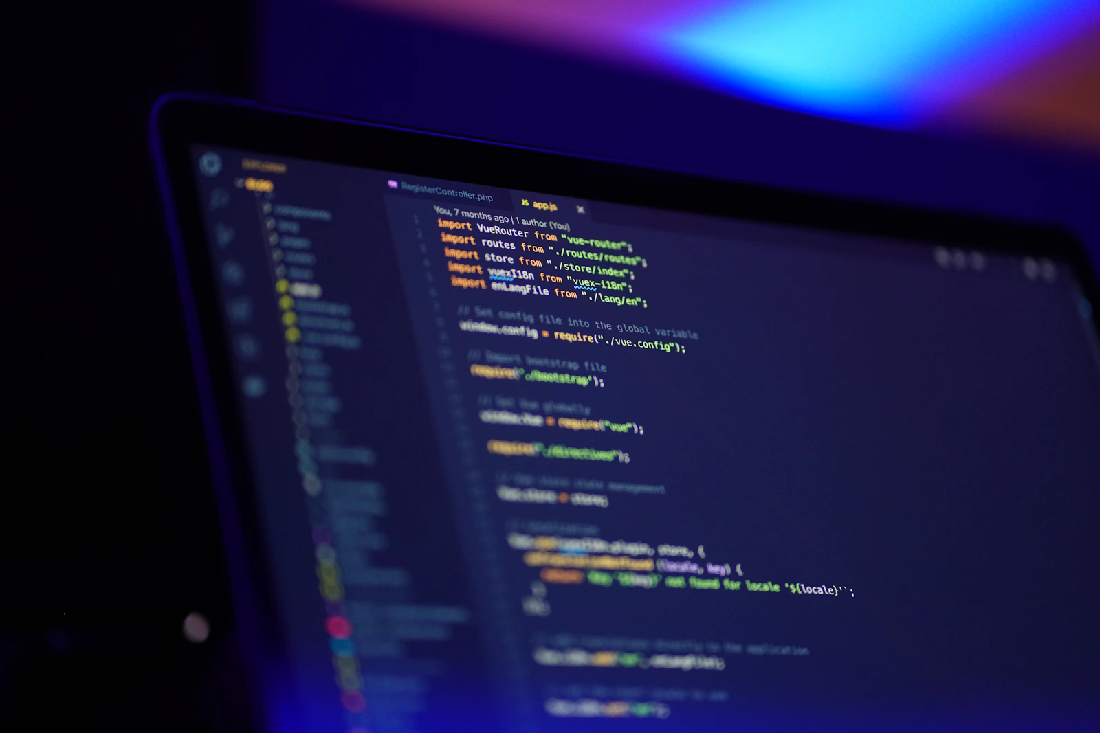 A laptop screen showing code under blue light